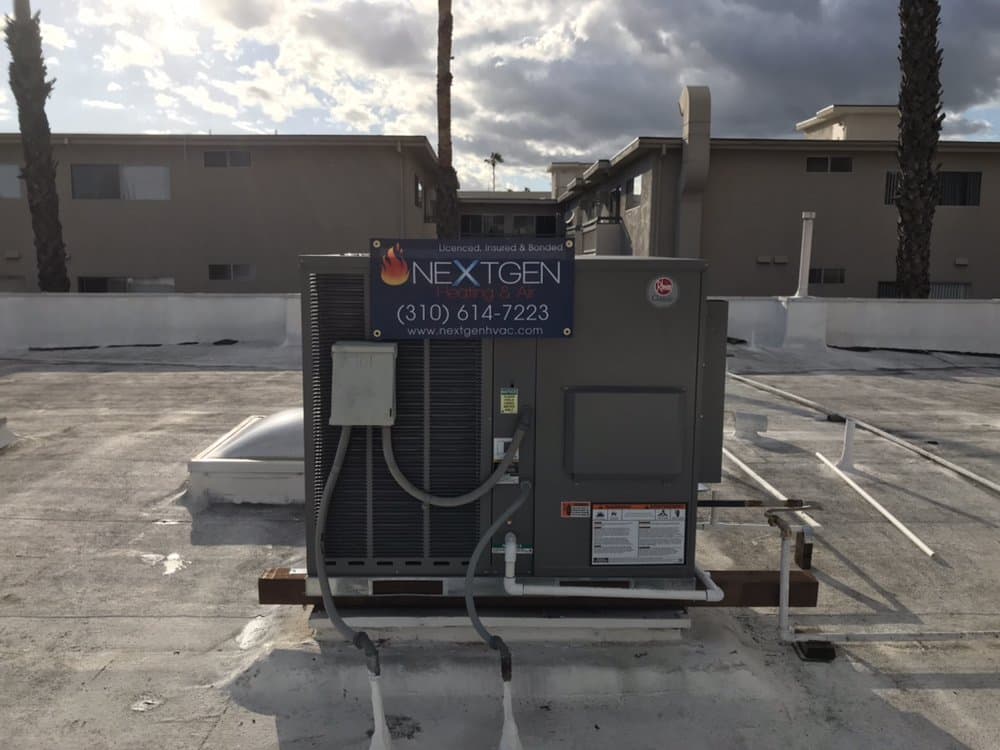 Package heat pump installed by NextGen, carrying their own jobsite banner with the flame logo and phone number