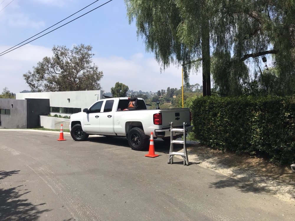 NextGen's Silverado and ladder set up outside a modern hillside home
