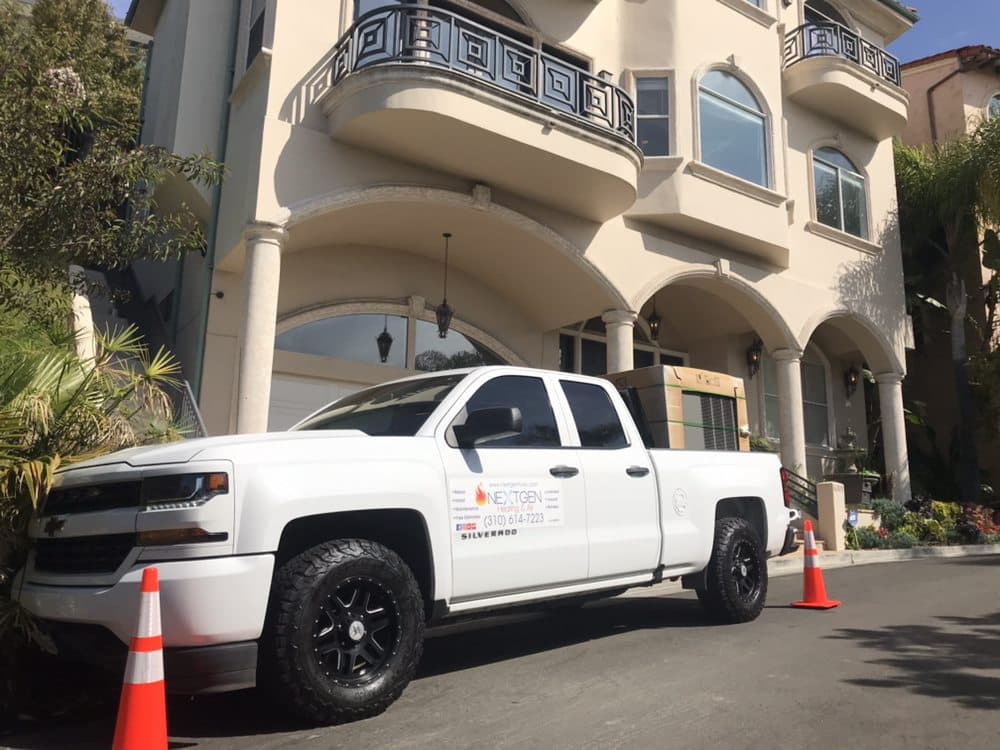 NextGen's branded Silverado parked outside a large LA home during a package-unit change-out